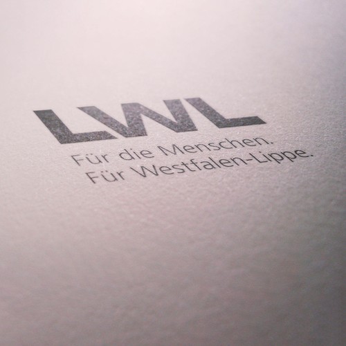 Foto eines Stempelabdrucks des LWL-Logos mit dem Claim: Für die Menschen. Für Westfalen-Lippe.